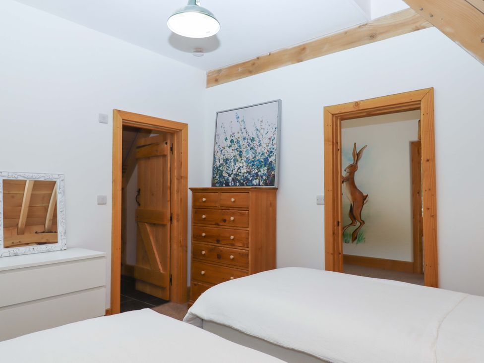 A bedroom with a chest of drawers and a mirror at Pucklechurch in Kingsteignton