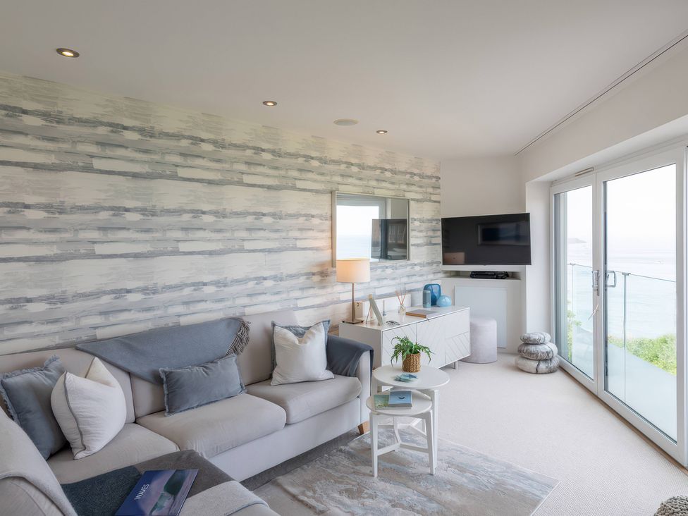 A living room with a sofa and television at 7 Atlantic Watch in Carbis Bay