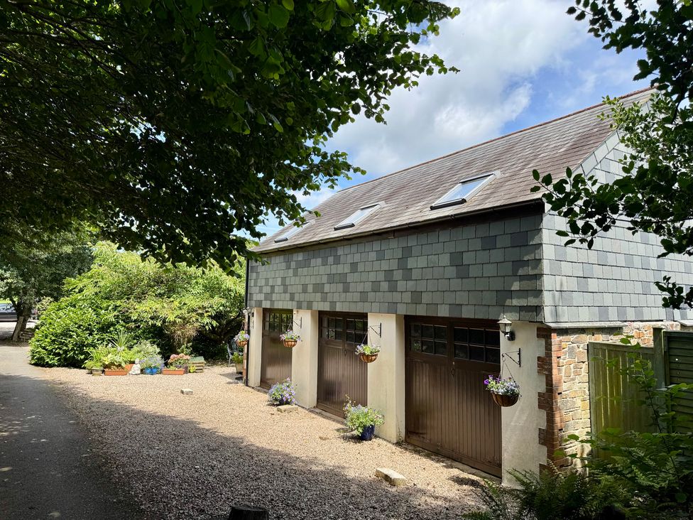 A garage with a pathway and plants at The Hayloft in Lostwithiel