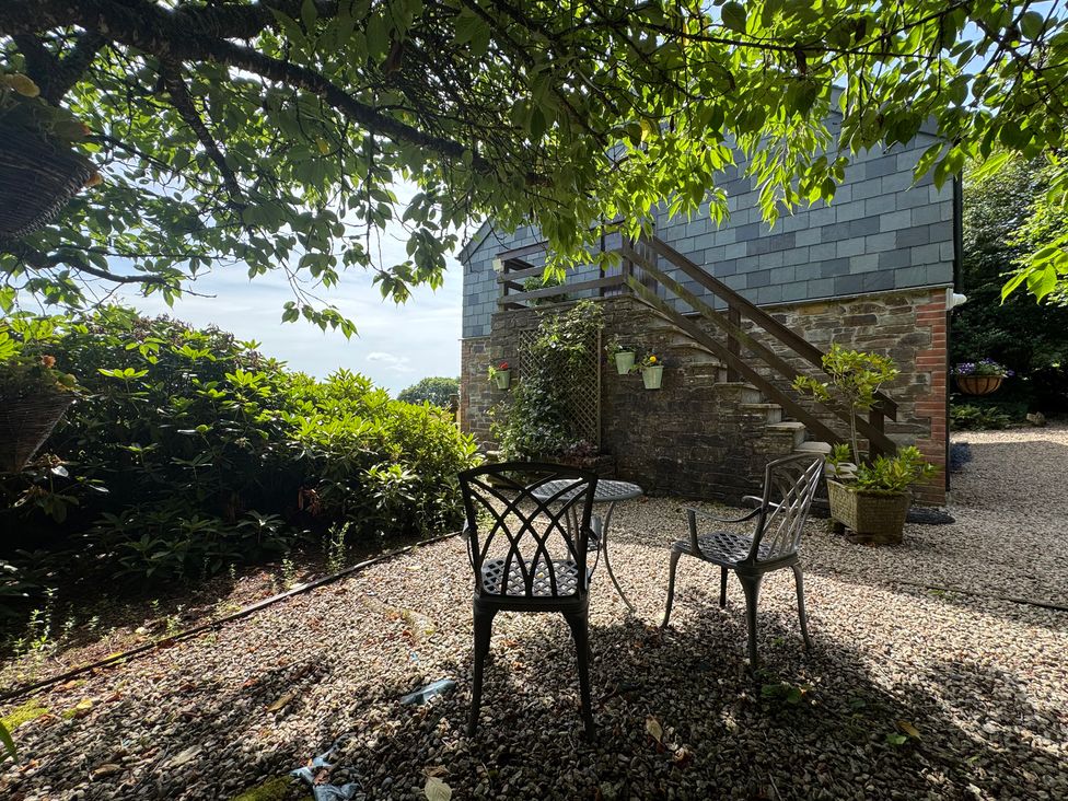 A garden with two chairs and a table at The Hayloft in Lostwithiel