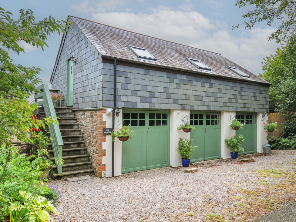 A building with garage doors and steps at The Hayloft in Lostwithiel