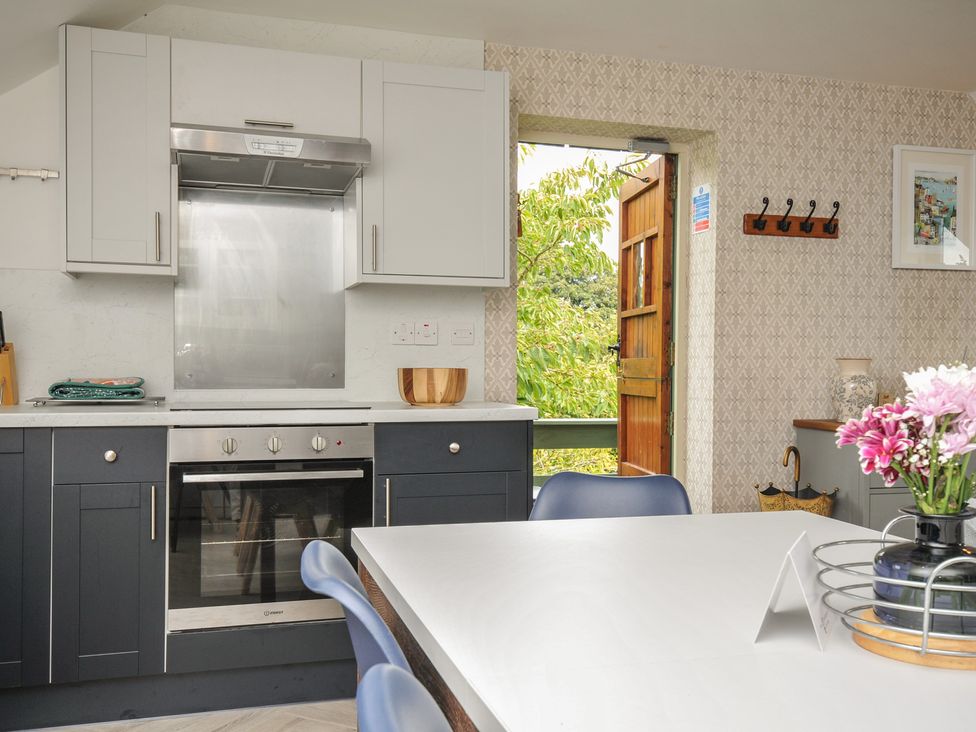A kitchen with cabinets and appliances at The Hayloft in Lostwithiel