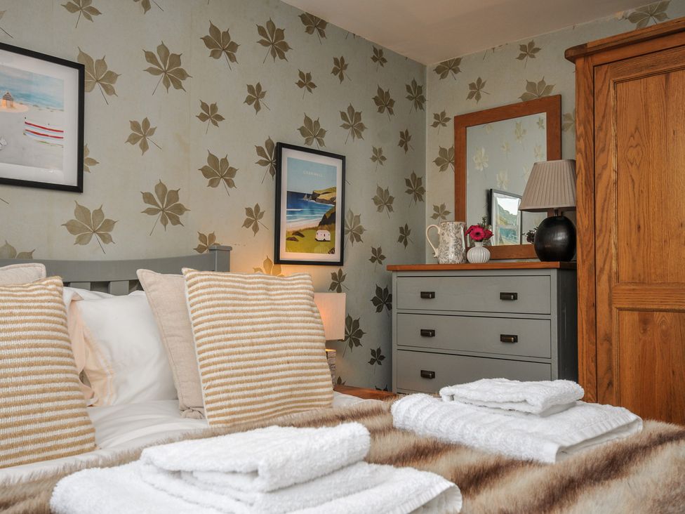 A bedroom with a bed and dressing table at The Hayloft in Lostwithiel