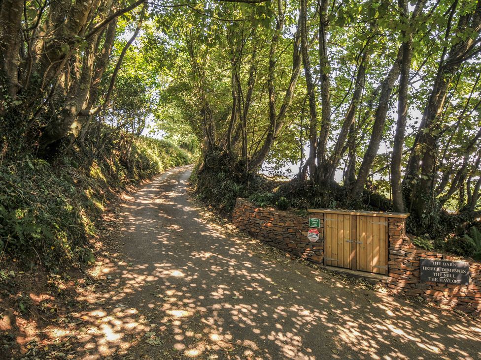 A path with trees and a gate at The Hayloft in Lostwithiel