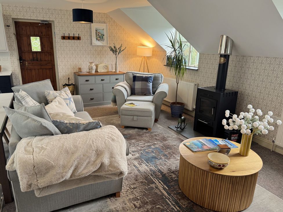 A living room with a sofa and armchair at The Hayloft in Lostwithiel