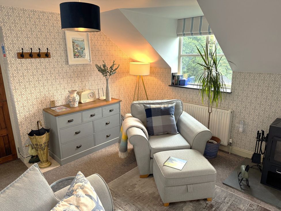 A living room with an armchair and chest of drawers at The Hayloft in Lostwithiel