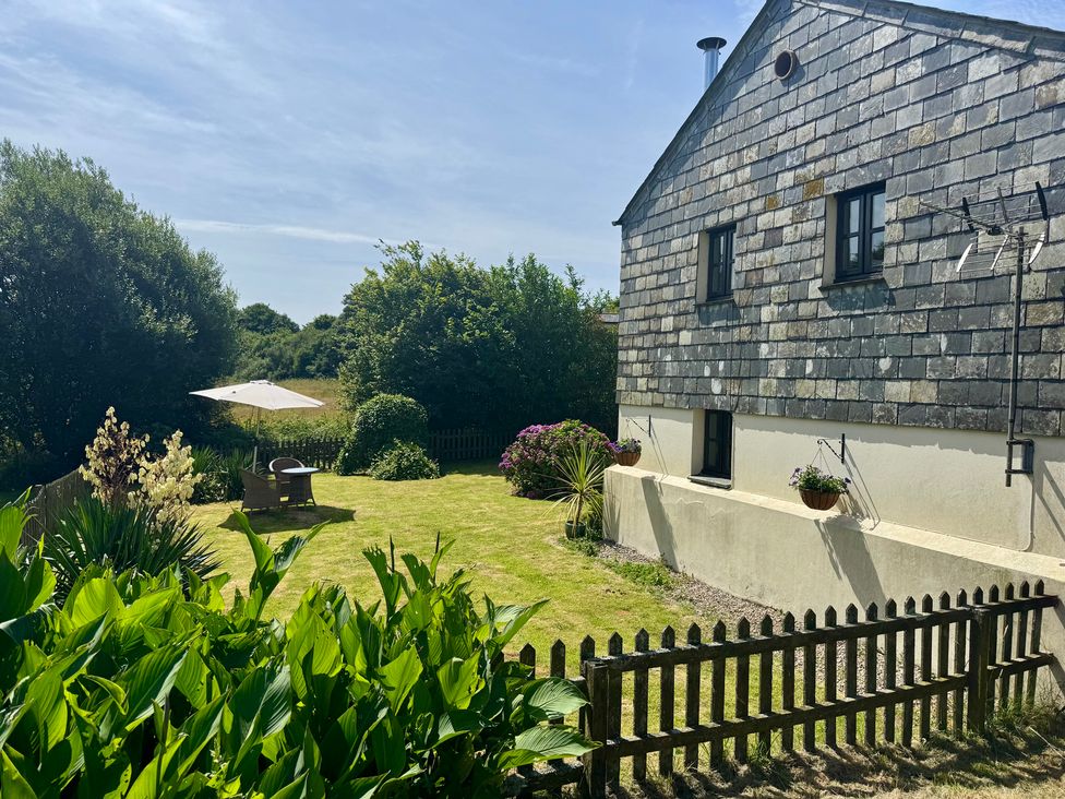 A garden with a house and seating area at The Mill in Lostwithiel