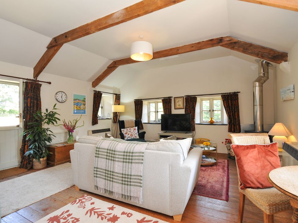 A living room with a sofa and television at The Mill in Lostwithiel