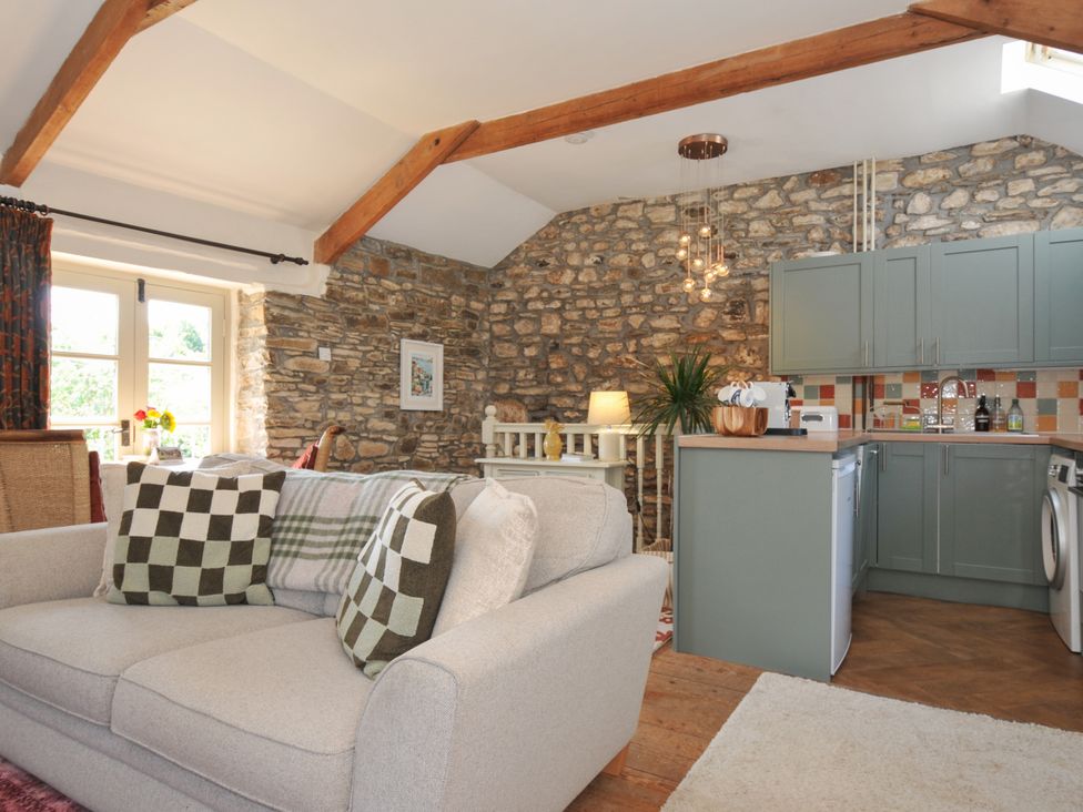 A living room with kitchen area at The Mill in Lostwithiel
