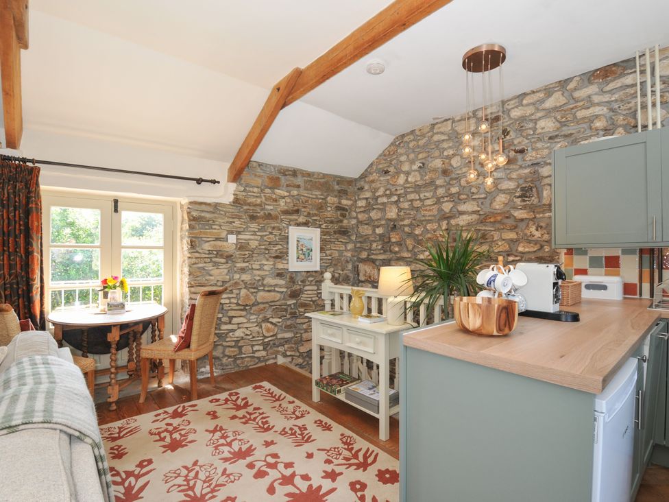 A living room with a table and chairs at The Mill in Lostwithiel