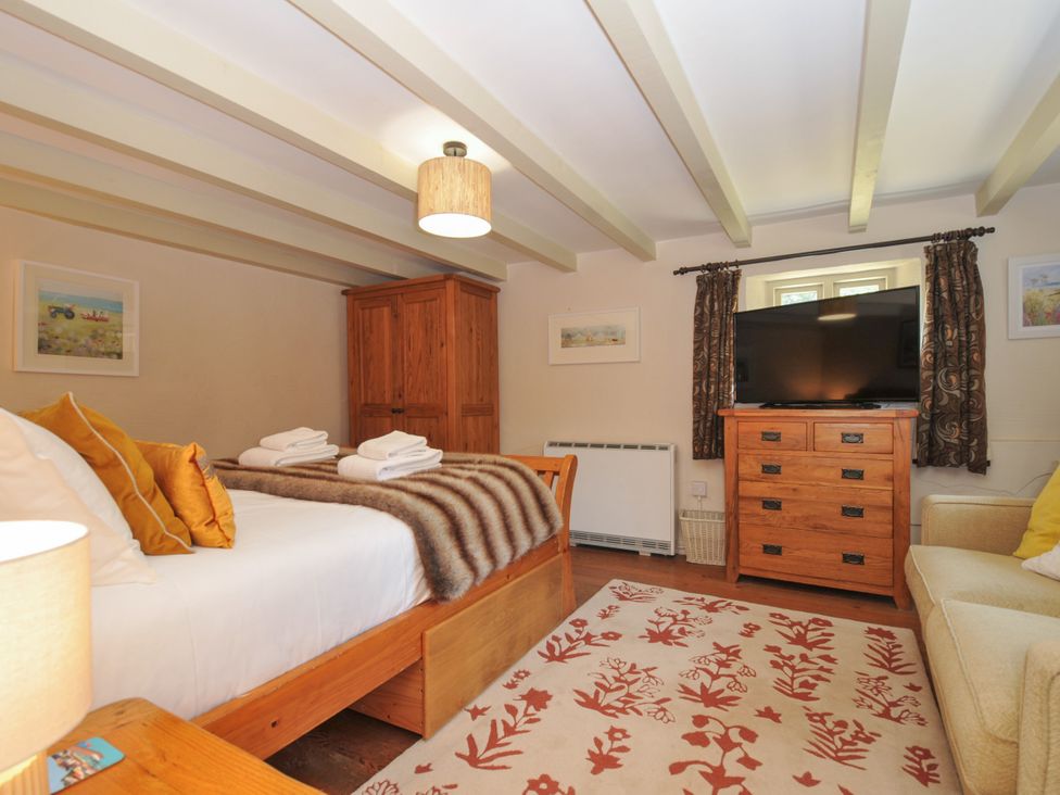 A bedroom with a bed and television at The Mill in Lostwithiel
