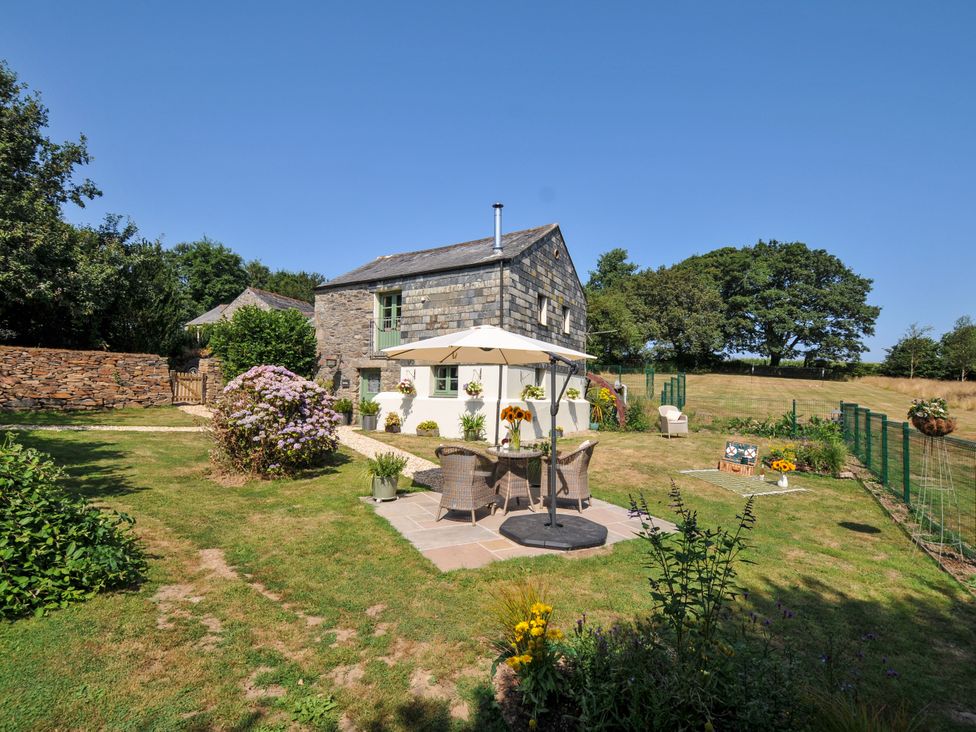A garden with a house and patio seating at The Mill in Lostwithiel