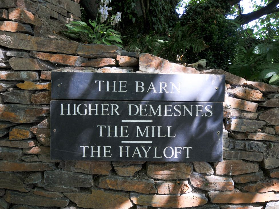 A sign indicating The Barn, Higher Demesnes, The Mill, and The Hayloft at The Mill in Lostwithiel