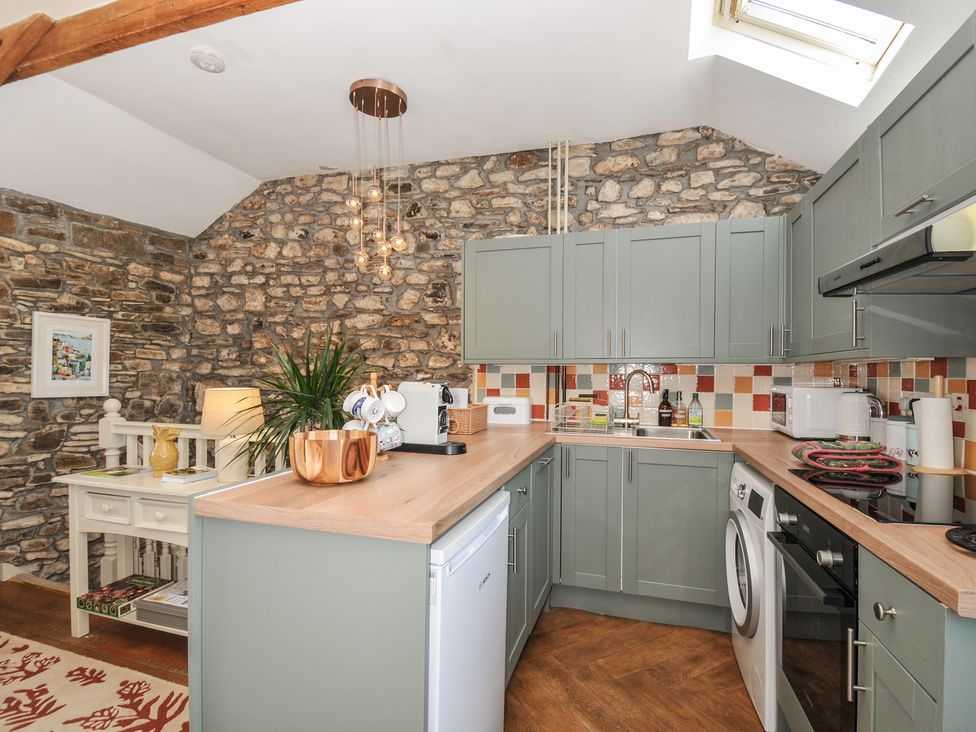 A kitchen with cabinets and appliances at The Mill in Lostwithiel