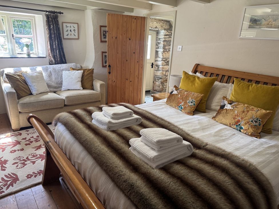 A bedroom with a bed and sofa at The Mill in Lostwithiel