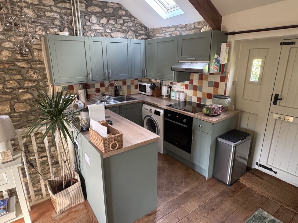 A kitchen with cabinets, sink, stove and appliances at The Mill in Lostwithiel