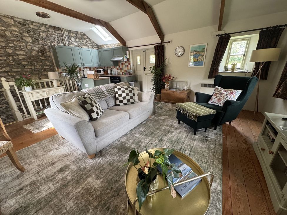 A living room with a couch and armchair at The Mill in Lostwithiel