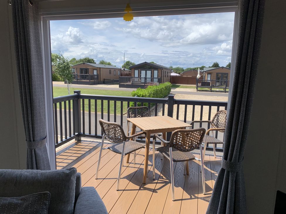 A balcony with a table and chairs at Longdon Lodge in Wickhamford near Evesham