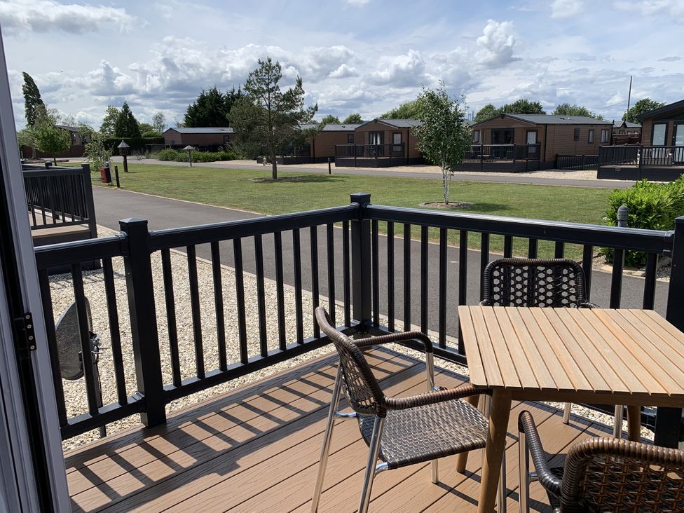 An outdoor seating area with table and chairs at Longdon Lodge in Wickhamford near Evesham