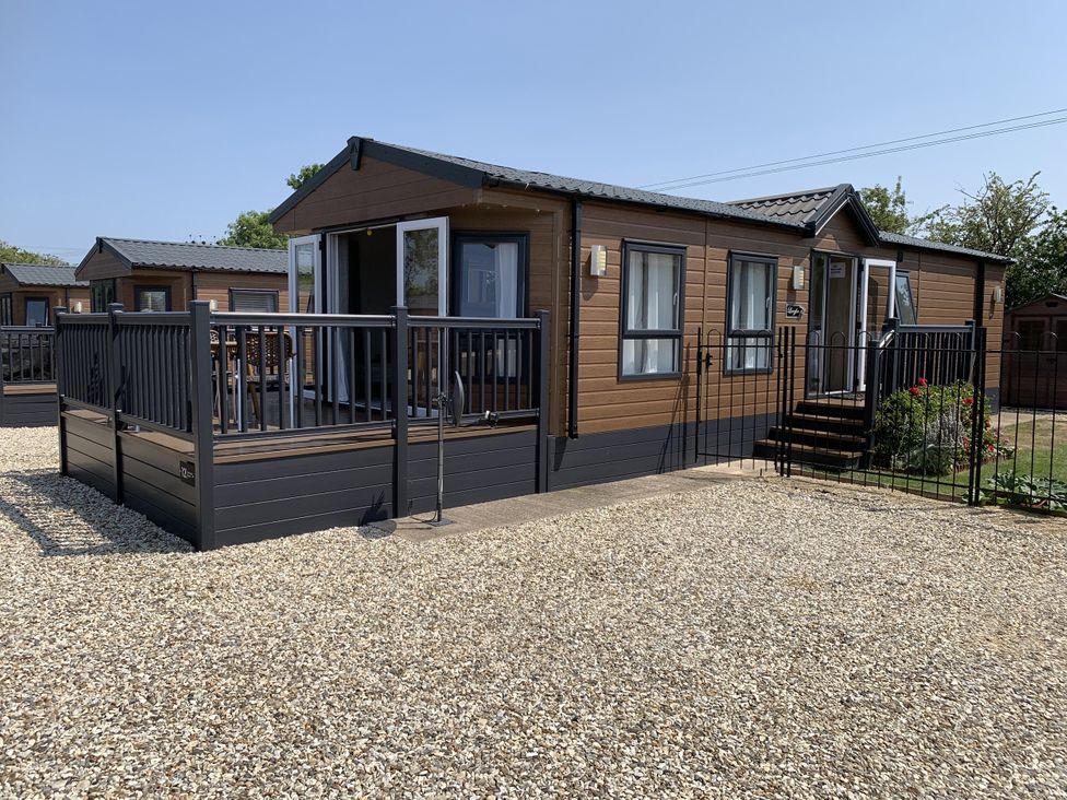 A mobile home with decking and gravel at Longdon Lodge in Wickhamford near Evesham