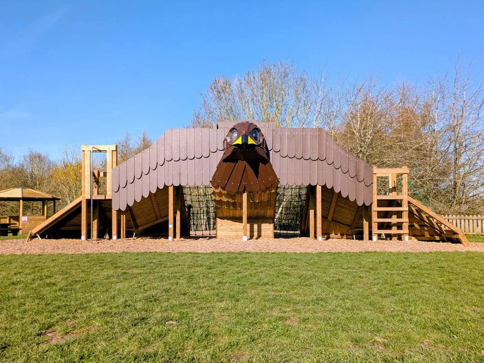 A playground with a large eagle-shaped climbing structure at Rowan Lodge in Rosliston