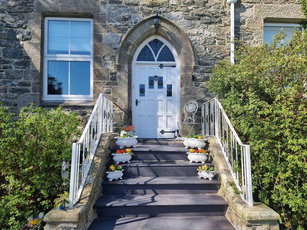 An outdoor entryway with a front door and flower pots at Ashleigh House
