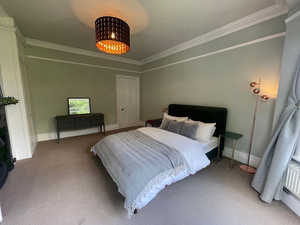 A bedroom with a bed, dresser, and lamp at Montclair