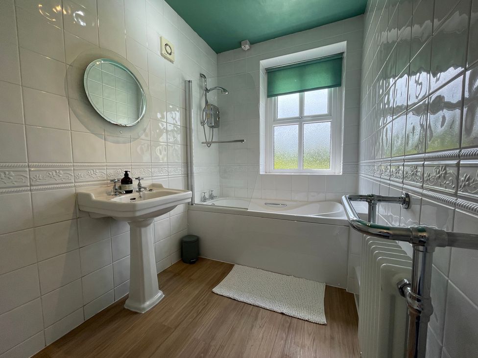 A bathroom with a sink, mirror, bath tub and shower at Montclair 