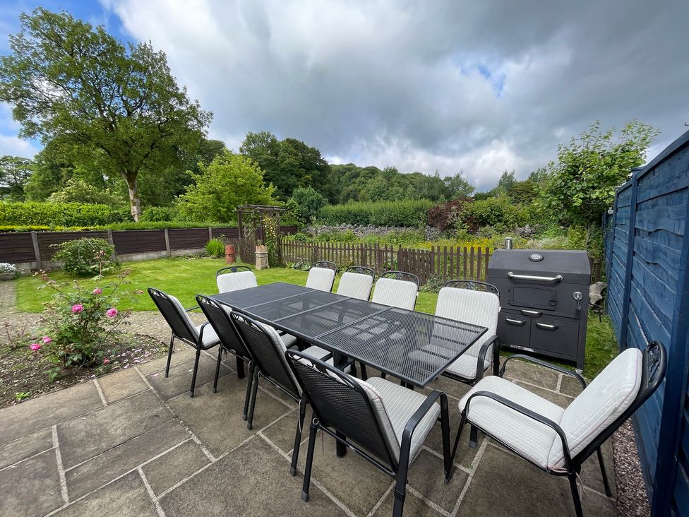 A garden with a dining table and chairs alongside a grill at Montclair 