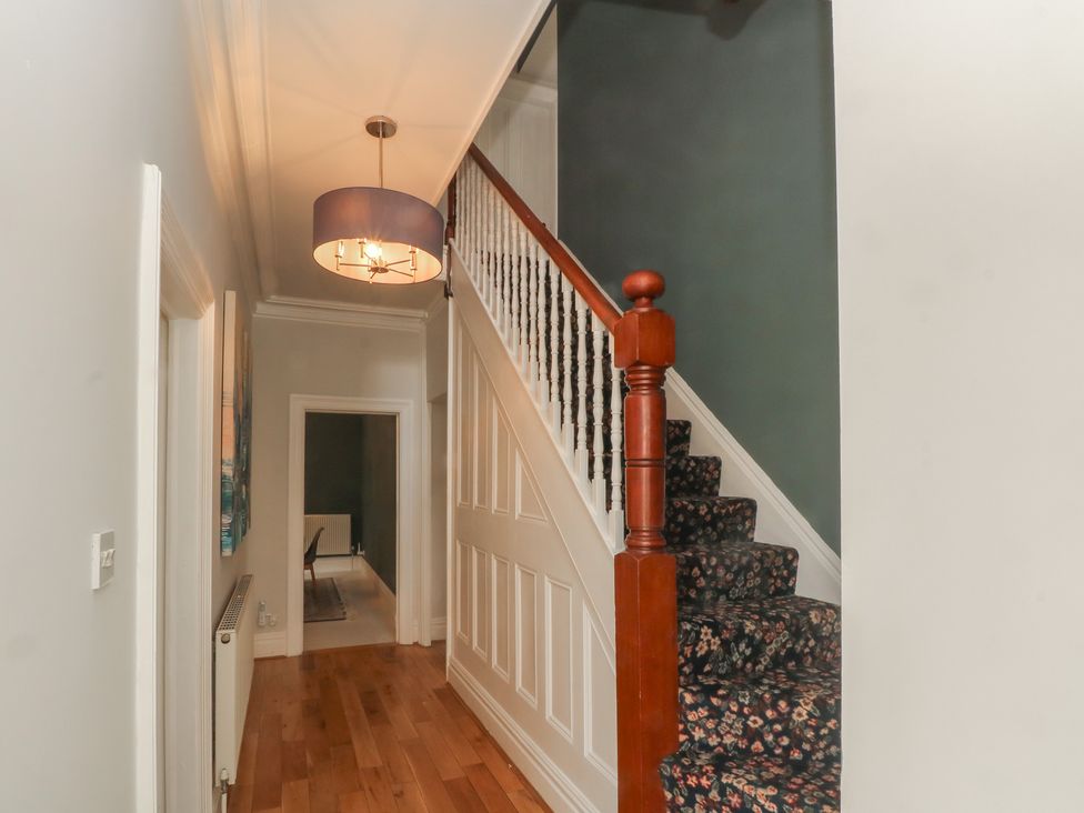A hallway with a staircase and light fixture at Montclair in Buxton