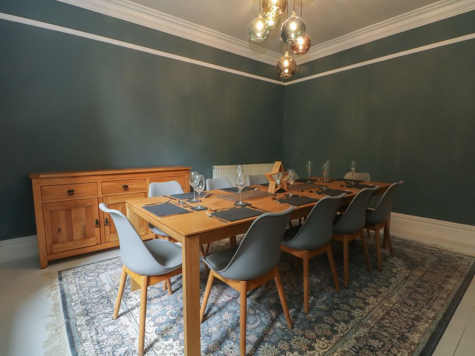 A dining room with a wooden table and chairs at Montclair in Buxton