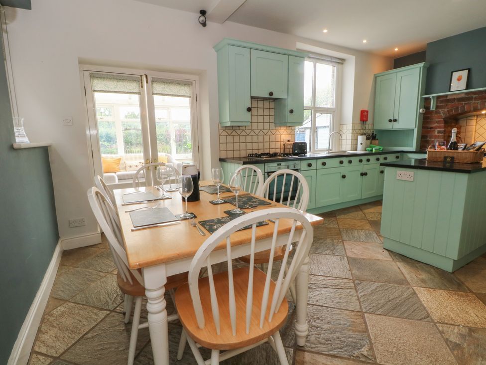 A kitchen with a dining table and chairs at Montclair in Buxton