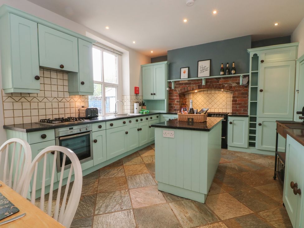 A kitchen with green cabinets and a stove at Montclair in Buxton