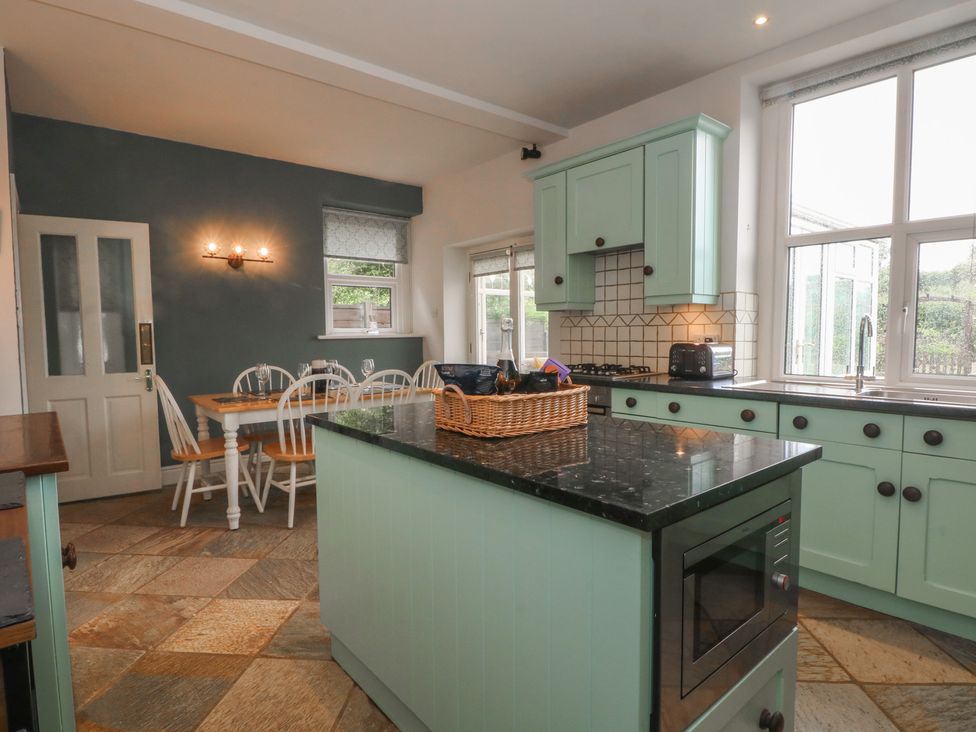 A kitchen with a dining table and white chairs at Montclair in Buxton
