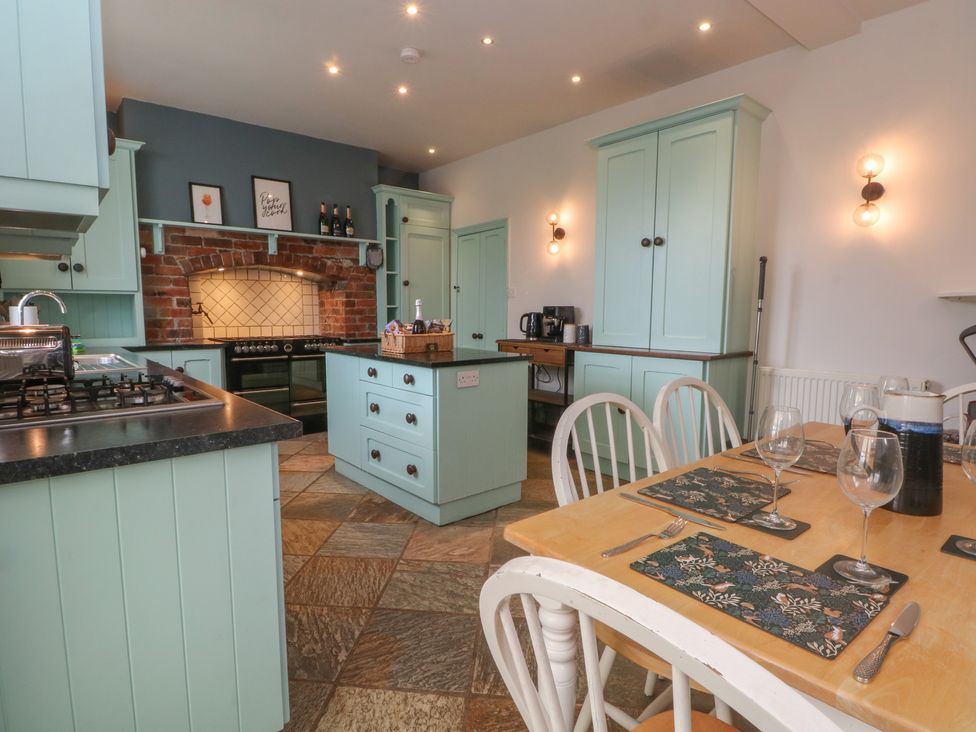 A kitchen with cabinets and dining table at Montclair in Buxton