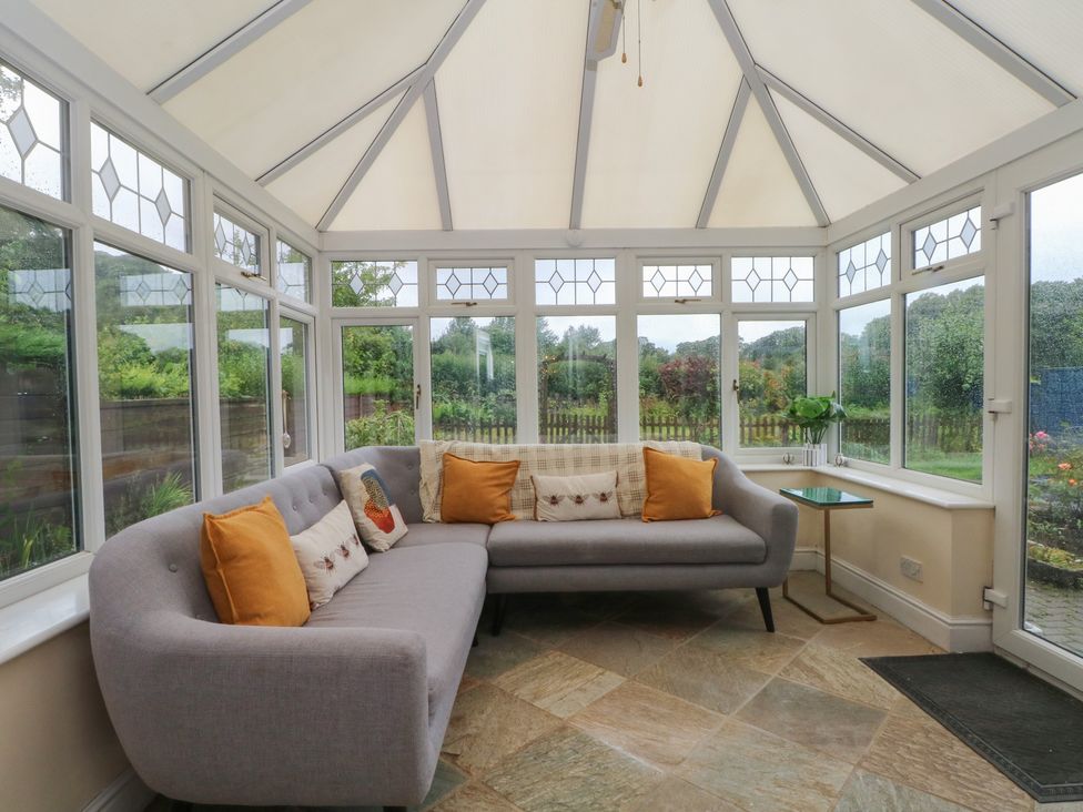 A conservatory with a sofa and table at Montclair in Buxton