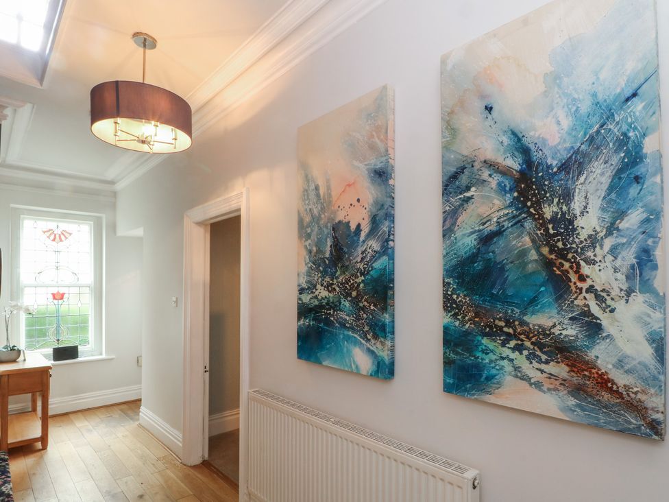 A hallway with wall art and a table at Montclair in Buxton