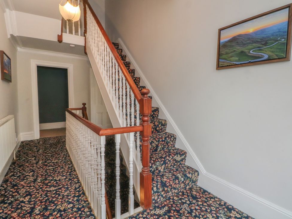 A hallway with a staircase and framed picture at Montclair in Buxton