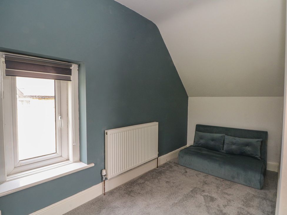 A bedroom featuring a window, radiator, and sofa at Montclair in Buxton