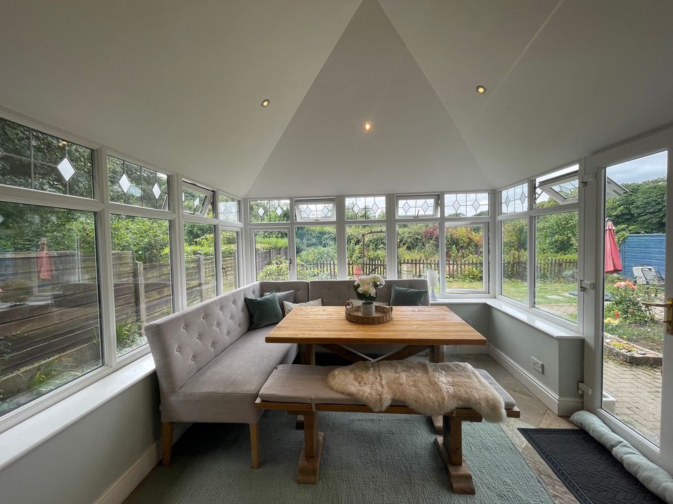 A conservatory with a table and bench at Montclair in Buxton