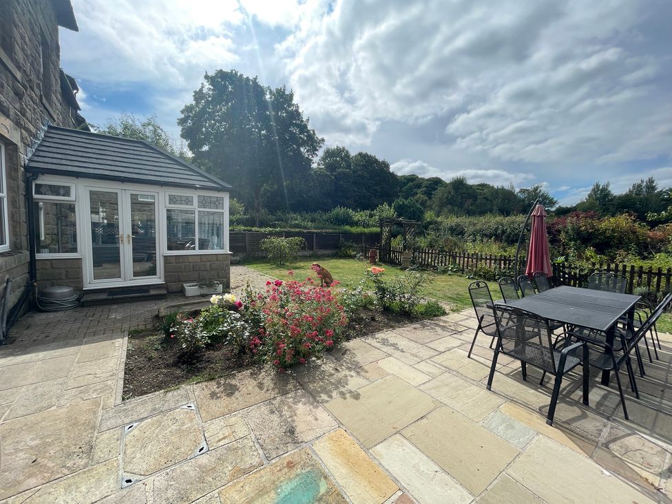 A garden with a conservatory and outdoor seating area at Montclair in Buxton