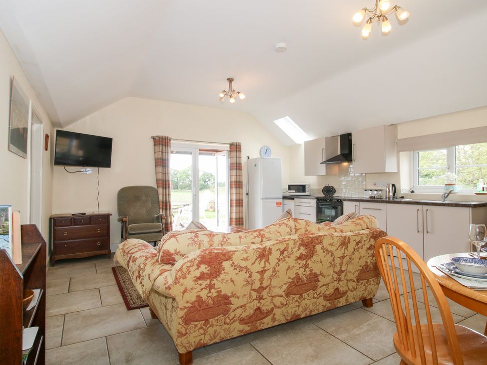 A living room with a sofa and television at Millstone Cottages - Millstone Cottage, Westbury
