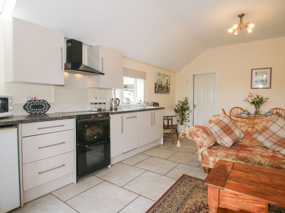 A kitchen with a sofa and dining table at Millstone Cottages - Millstone Cottage in Westbury