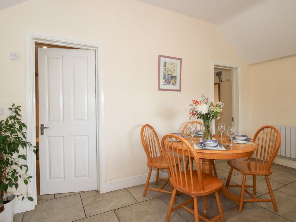 A dining room with a table and chairs at Millstone Cottages - Millstone Cottage in Westbury