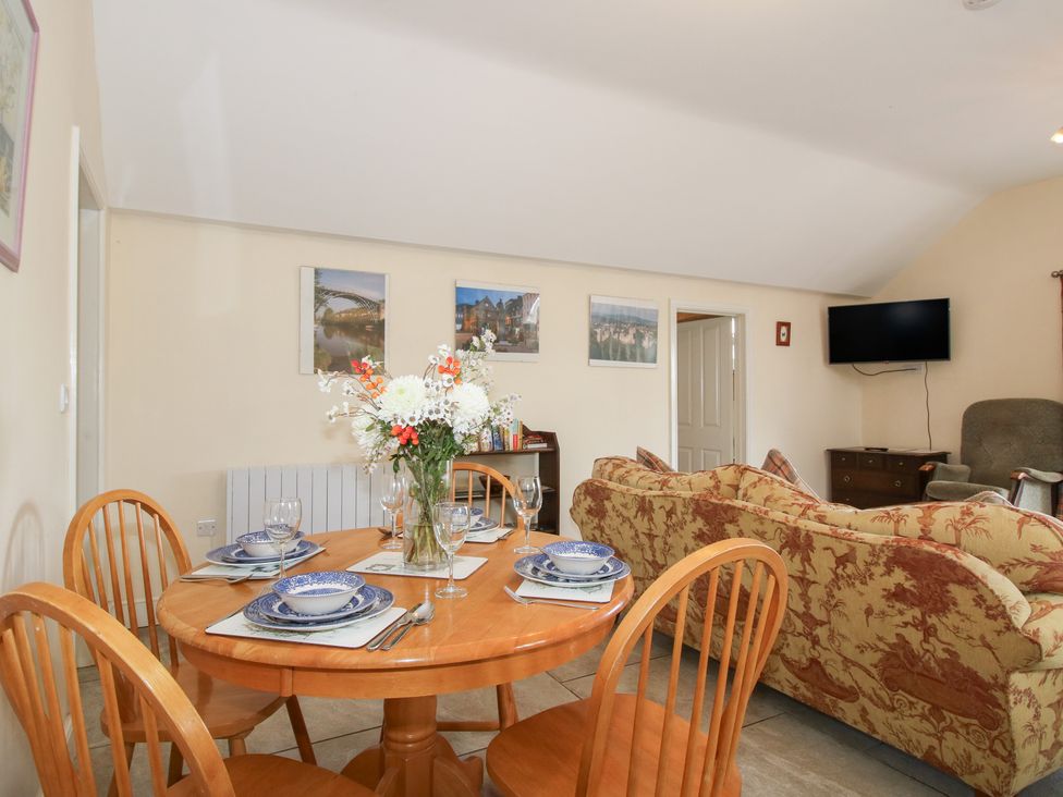 A dining room with a table and chairs at Millstone Cottages - Millstone Cottage in Westbury