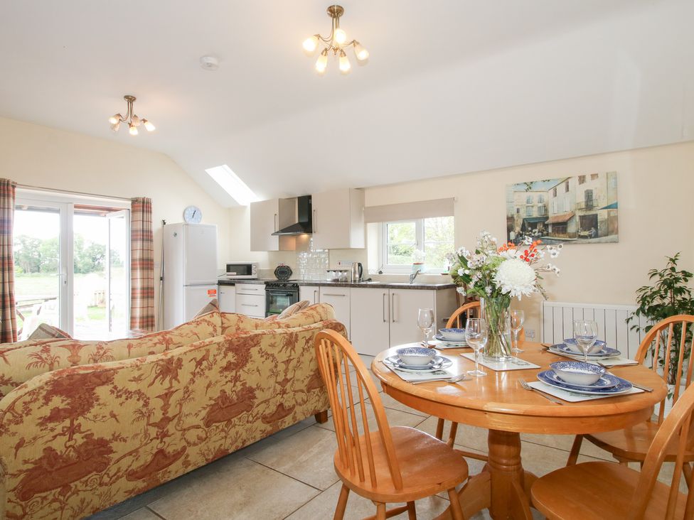 A kitchen with a dining area and appliances at Millstone Cottages - Millstone Cottage in Westbury