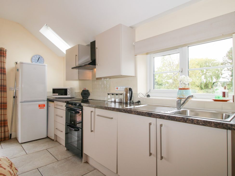 A kitchen with refrigerator and stove at Millstone Cottages - Millstone Cottage Westbury