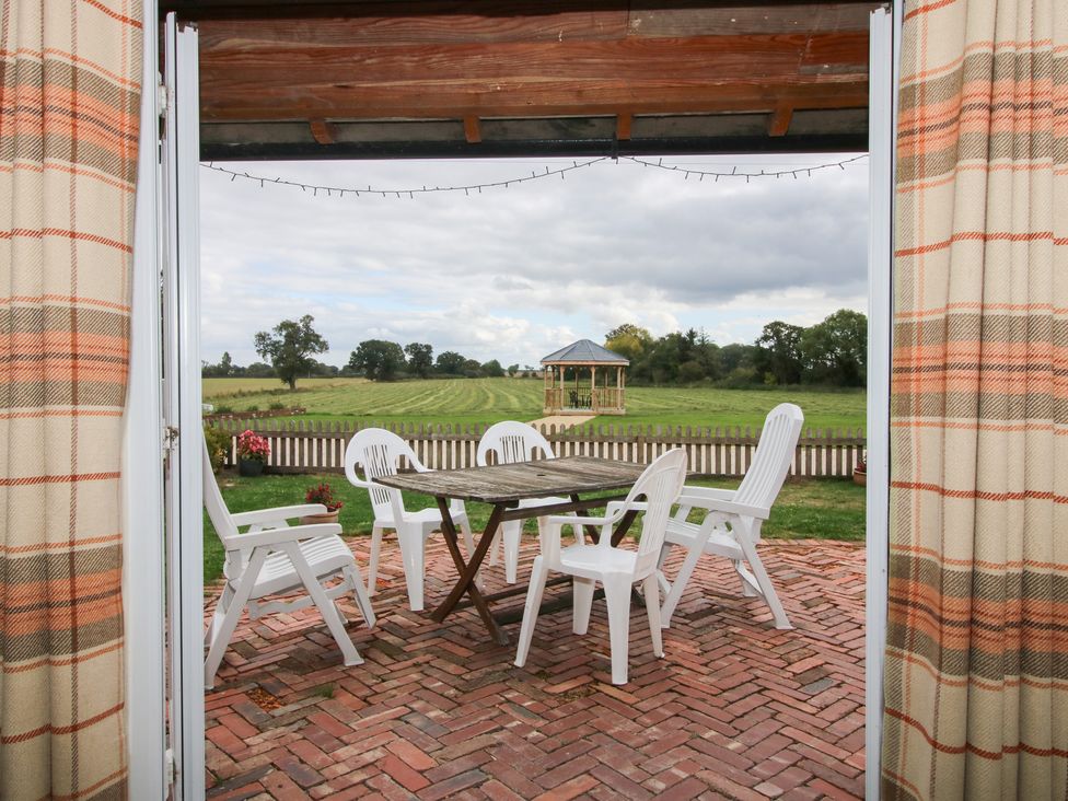 An outdoor seating area with a table and chairs at Millstone Cottages - Millstone Cottage in Westbury
