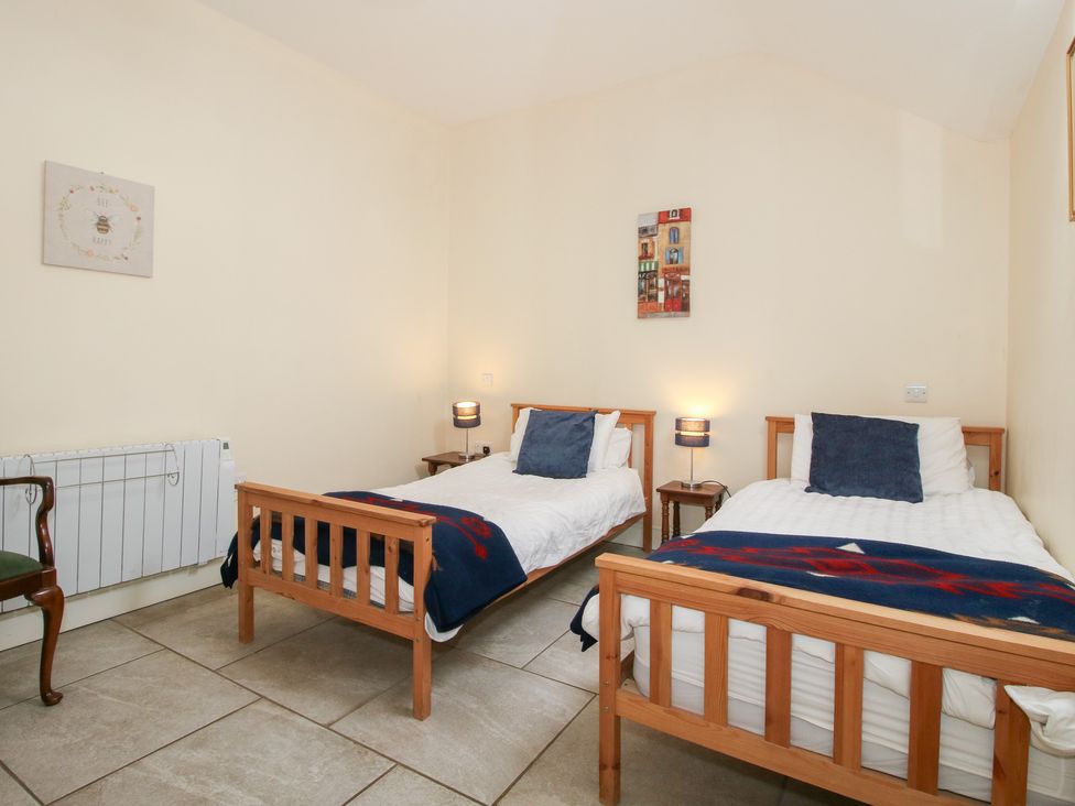 A bedroom with two single beds at Millstone Cottages - Millstone Cottage in Westbury
