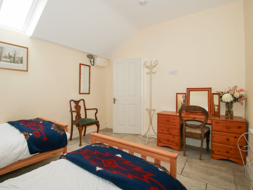 A bedroom with two beds and a dresser at Millstone Cottages - Millstone Cottage in Westbury